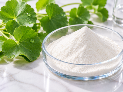 Madecassoside white botanical active ingredient powder in a glass dish with Centella asiatica leaves